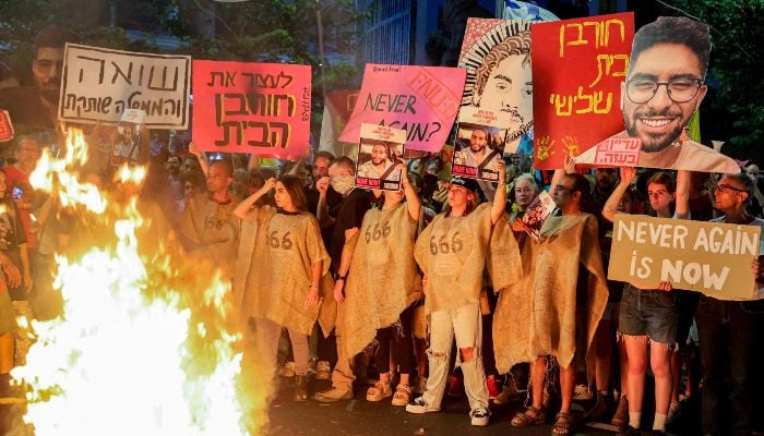 Demonstrators gather before a bonfire during an anti-government protest, outside the Israeli Defence Ministry headquarters in Tel Aviv on August 2, 2025. — AFP