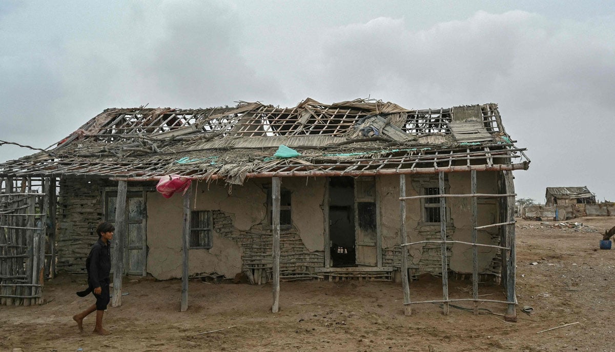 A boy walks past an abandoned house in one of the villages of Kharo Chan town, in the Indus delta on June 25, 2025. — AFP