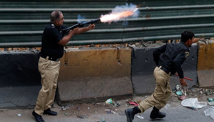 A police officer fires teargas to disperse PTI supporters during a nationwide protest demanding Khans release on the second anniversary of his jailing, in Karachi on August 5, 2025. — Reuters