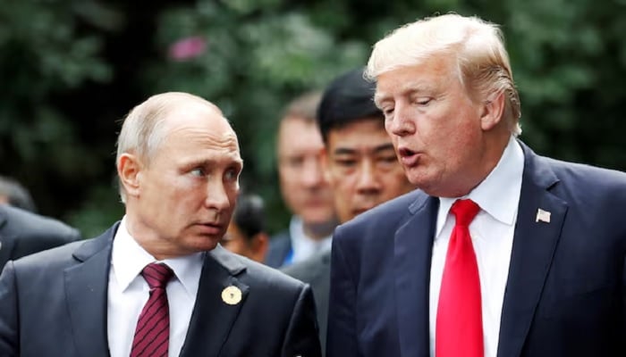 US President Donald Trump and Russias President Vladimir Putin talk during the family photo session at the APEC Summit in Danang, Vietnam, November 11, 2017. —Reuters