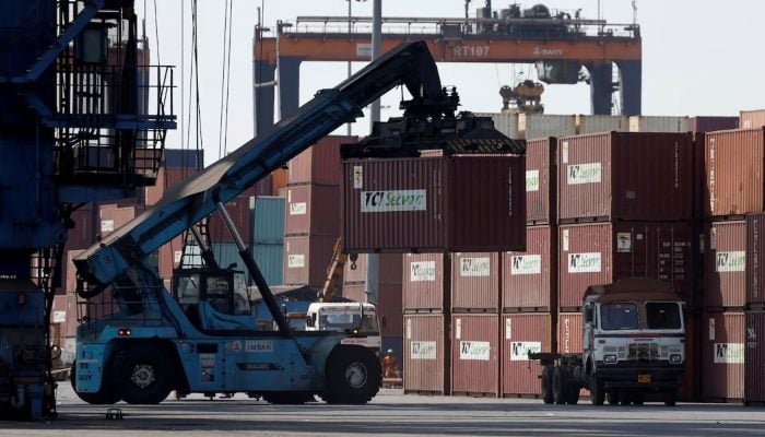 A mobile crane carries a container at Deendayal Port in Kandla, in the western state of Gujarat, India, April 5, 2025. — Reuters