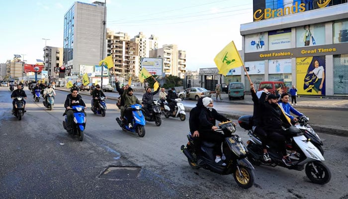 Men carry Hezbollah flags while riding on two wheelers, at the entrance of Beiruts southern suburbs, in Lebanon, November 27, 2024. — Reuters