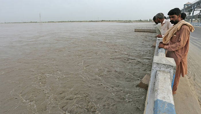 Commuters watch overflowing River Sutlej at Islam Headworks in Hasilpur, in Punjab on August 26, 2023. — AFP/File