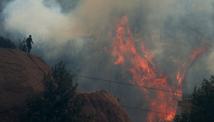 A person walks, as a wildfire continues to burn in Delvina, Albania, August 13, 2025. — Reuters