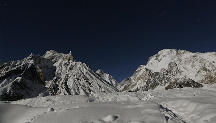 The worlds second largest mountain, K2 (seen in the distance), and Broad Peak (right), are illuminated by the moon at Concordia, the confluence of the Baltoro and Godwin-Austen glaciers, in the Karakoram mountain range in Pakistan September 7, 2014. — Reuters