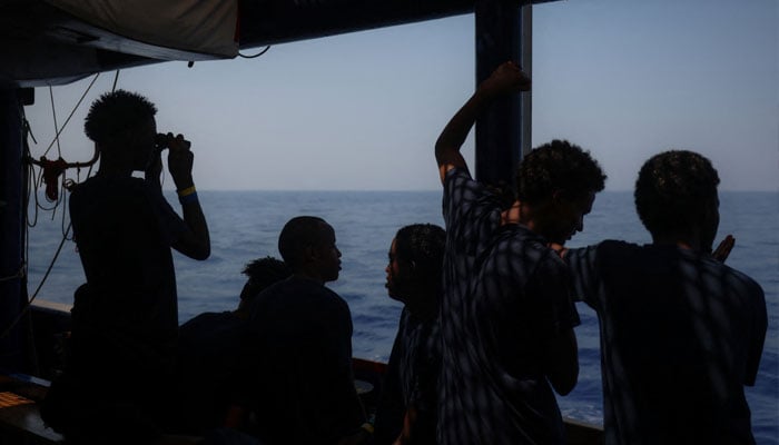 A young migrant looks for land through binoculars, aboard the migrant search and rescue ship Sea-Watch 5, operated by German NGO Sea-Watch, as the ship makes its way towards the designated port of Salerno, Italy, August 13, 2025. — Reuters