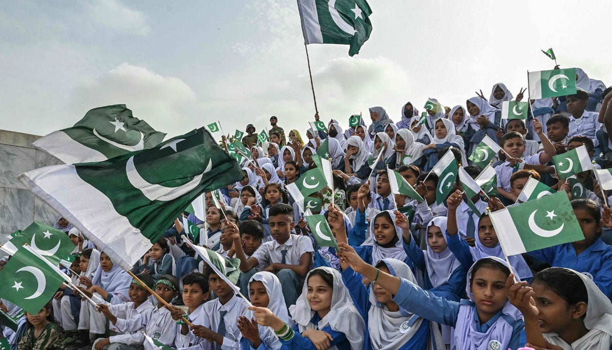 Students wave national flags during Independence Day celebrations at the mausoleum of Muhammad Ali Jinnah, in Karachi on August 14, 2025. — AFP