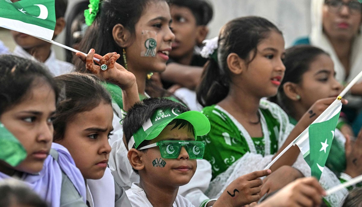 Students wave national flags during Independence Day celebrations at the mausoleum of Muhammad Ali Jinnah, in Karachi on August 14, 2025. — AFP