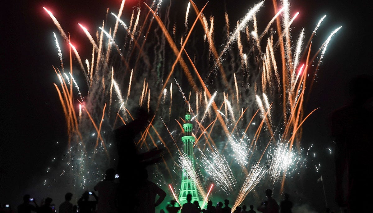 People watch fireworks exploding over the illuminated Minar-e-Pakistan monument during the celebration of Independence Day in Lahore on August 14, 2025. — Reuters