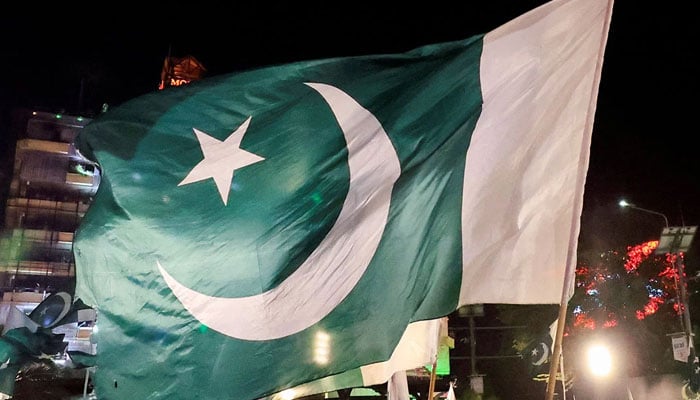 People wave national flags as they gather on the eve of Pakistans Independence Day in Lahore on August 13, 2025. — Reuters