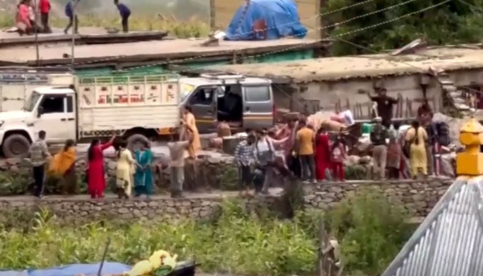 Residents gather along a roadside after heavy rainfall in Indian Illegally Occupied Jammu and Kashmir (IIOJK) on August 14, 2025. — Screengrab/Reuters