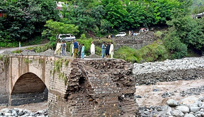 Onlookers gather near a destroyed bridge after flash floods on the outskirts of Muzaffarabad, the capital AJK, on August 15, 2025. — AFP