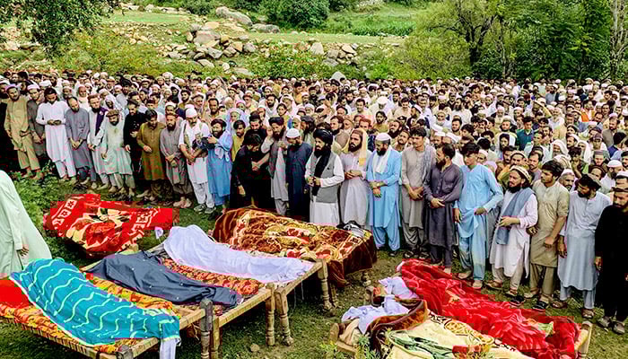 Mourners and locals offer funeral prayers for victims who died in incidents related to flash floods and monsoon rains in Salarzai Tehsil of Bajaur district on August 15, 2025. — AFP