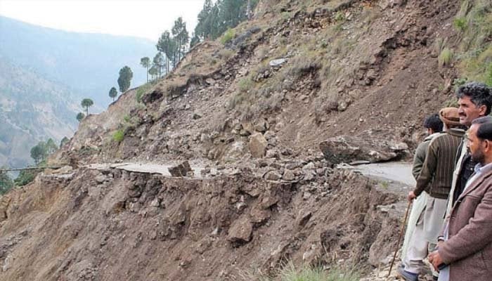 This undated picture shows people standing near a landslide site at an undisclosed location. — Geo Tv/File