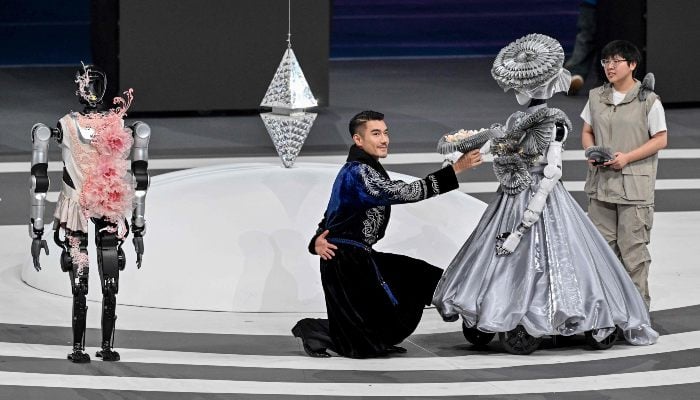 People and robots take part in the opening ceremony of the World Humanoid Robot Games in Beijing on August 14, 2025. — AFP