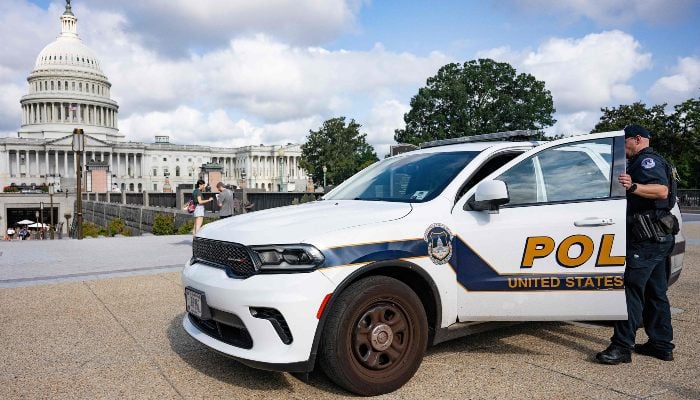 An US Capitol Police office enters his car parked on the side walk near the US Capitol in Washington, DC, on August 8, 2025. — AFP