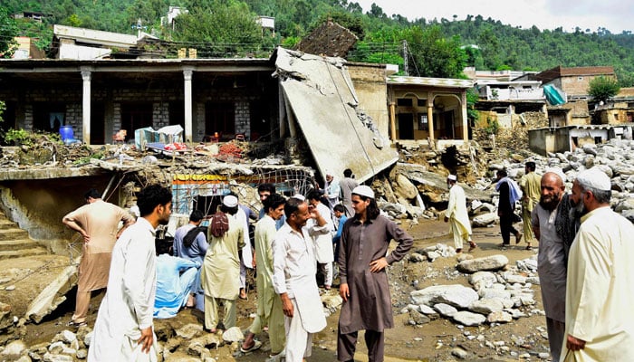 Residents gather in front of damaged houses after flash floods in the Buner district of the monsoon-hit Khyber Pakhtunkhwa  on August 16, 2025. — AFP