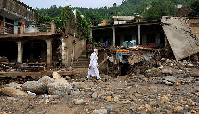 A resident walks past damaged houses, following a storm that caused heavy rains and flooding in KPs Bayshonai Kalay, in Buner district on August 17, 2025. — Reuters