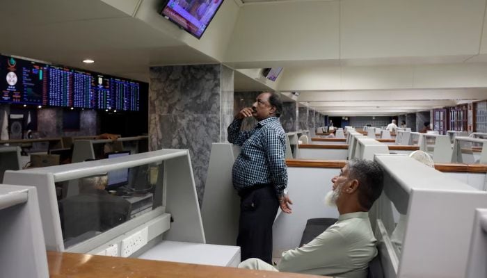 Stock brokers monitor new on television screen at a booth, during a trading session at the Pakistan Stock Exchange, in Karachi, July 3, 2023. — Reuters