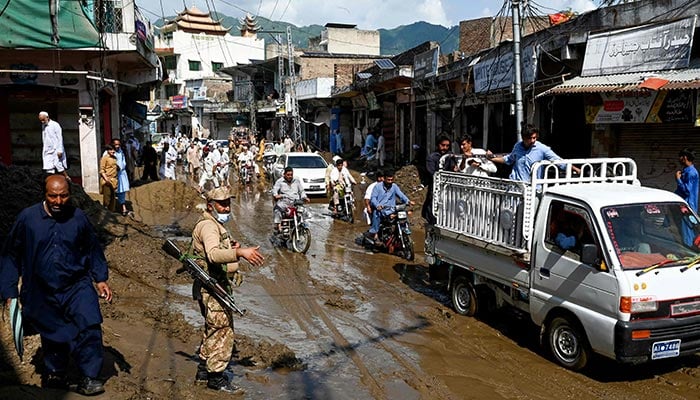 Army personnel clear traffic along a muddy road, after flash floods hit Buner, Khyber Pakhtunkhwa province on August 18, 2025. — AFP