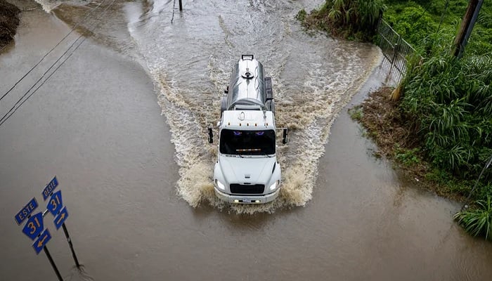 A truck drives through a flooded road as Category 3 Hurricane Erin leaves the region in Naguabo, Puerto Rico, on Aug. 16, 2025. —AFP