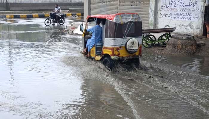 A rickshaw passes through an inundated road in Karachi after heavy rains on August 19, 2025. — Geo.tv