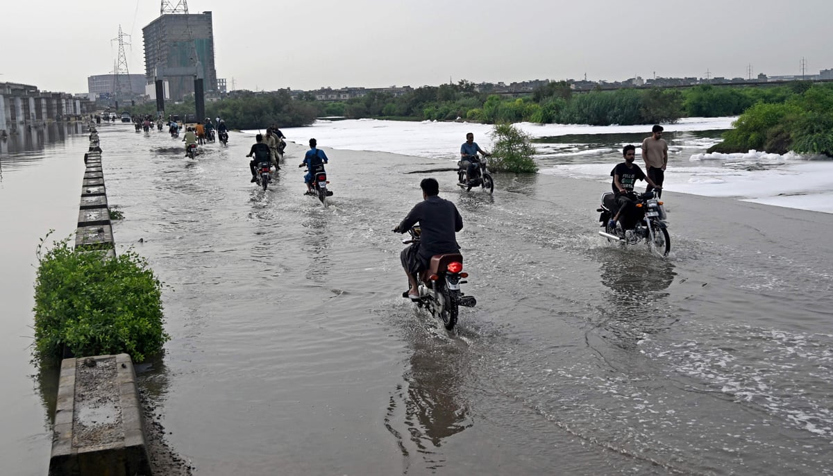 Motorists make their way through a flooded street after heavy monsoon rains in Karachi on August 20, 2025. — AFP