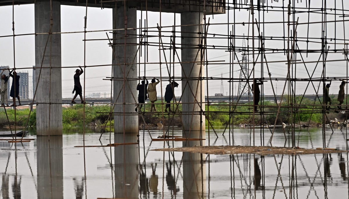 Labourers work at a flooded construction site after heavy monsson rains in Karachi on August 20, 2025. — AFP