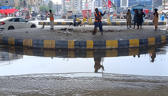 Sweepers clear a Karachi road a day after heavy rains battered the city, August 20, 2025. — Geo.tv