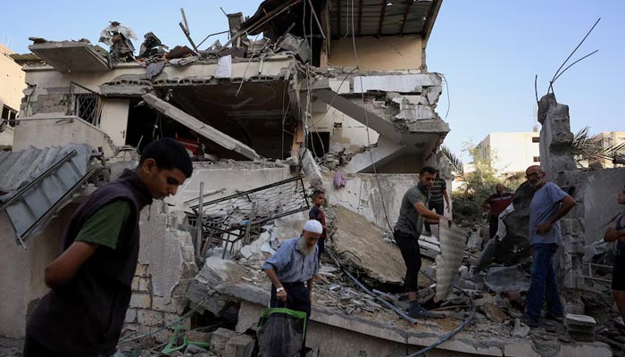 Palestinians inspect the site of an overnight Israeli strike on a house, in Gaza City, August 20, 2025. — Reuters
