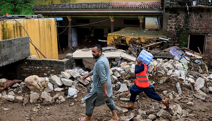 Men walk past a damaged house, following a storm that caused heavy rains and flooding in Dalori Bala village in Gadoon district in Khyber Pakhtunkhwa on August 19, 2025. — Reuters