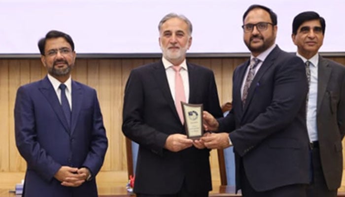 National Accountability Bureau (NAB) Chairman retired Lt-Gen Nazir Ahmed distributing shields to the B4U scam case team at cheque distribution ceremony of B4U scam at NAB headquarters on August 21, 2025. — NAB