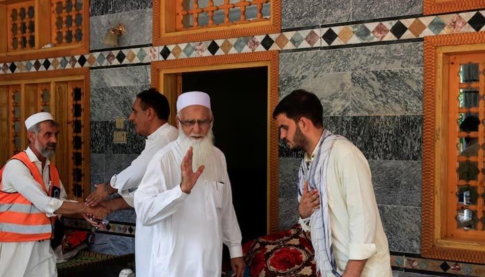 Noor Muhammad, 25, who lost 24 family members and relatives, receives guests at a condolence gathering at his 36-room family house, which was hit by devastating floods in Buner district. — Reuters