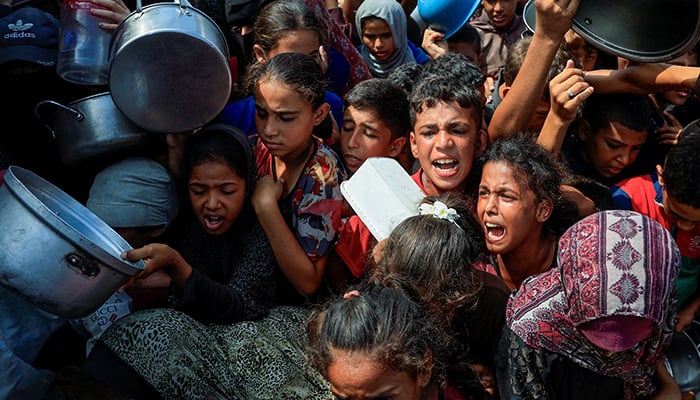 Palestinians wait to receive food from a charity kitchen, in Khan Younis, southern Gaza Strip, August 21, 2025. — Reuters