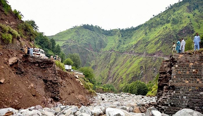 Onlookers gather near a destroyed bridge after flash floods on the outskirts of Muzaffarabad, the capital AJK, on August 15, 2025. — AFP