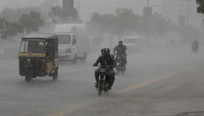 Commuters travel on a road during heavy rain in Karachi on August 20, 2025.  — Reuters