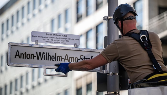 A worker installs a sign with the streets new name, after years of controversy and a last-minute courtroom drama over the old name, Moors Street. — AFP