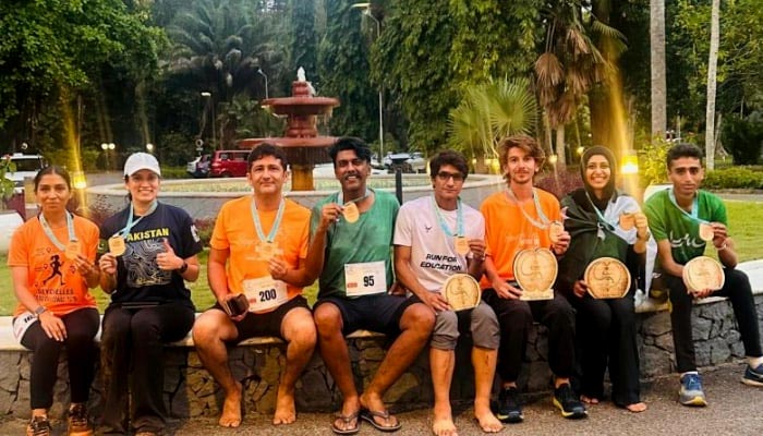 Pakistani journalist Raja Mohsin Ejaz (left) and Geo’s Deputy Sports Editor Faizan Lakhani (centre), along with other male and female participants, pose for a picture during the Seychelles Nature Trail Challenge 2025 at Mahé Island, Seychelles, on August 24, 2025. — Reporter