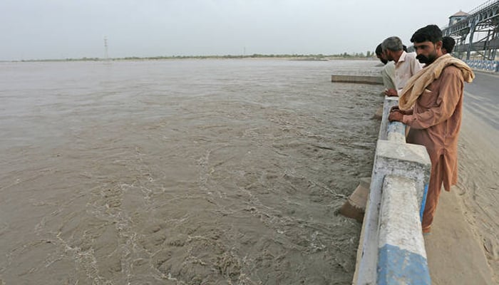 Commuters watch overflowing River Sutlej at Islam Headworks in Hasilpur, Punjab, on August 26, 2023. — AFP