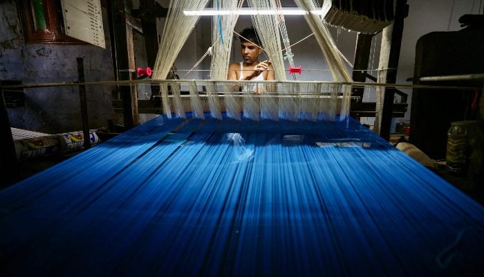 An artisan weaves a Banarasi saree on a handloom at a workshop in Varanasi, India, on August 25, 2025. — AFP