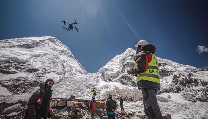 A man operates a heavy-lift drone to clear trash dumped at the Everest Base Camp. — AFP