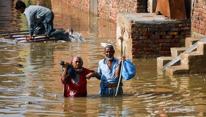 People wade through a flooded street after the rain at Latifabad, Hyderabad, Pakistan, August 22, 2025. — Reuters