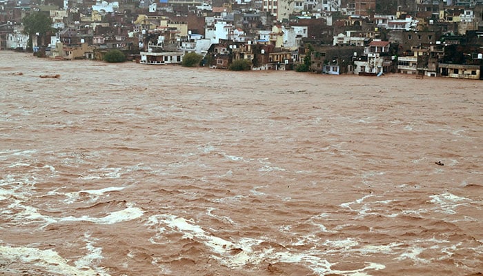 Water flows down the overflowing Tawi River following heavy rain in IIOJK on August 26, 2025. — Reuters