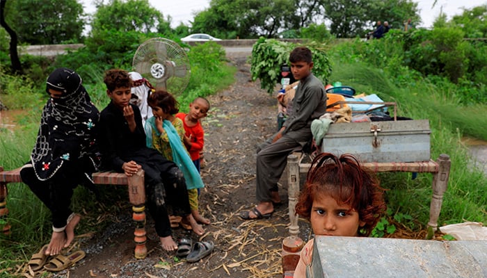 A family with their belongings takes refuge along a road near Chenab River, following the monsoon rains and rising water level in Wazirabad, in Punjab province, August 27, 2025. — Reuters