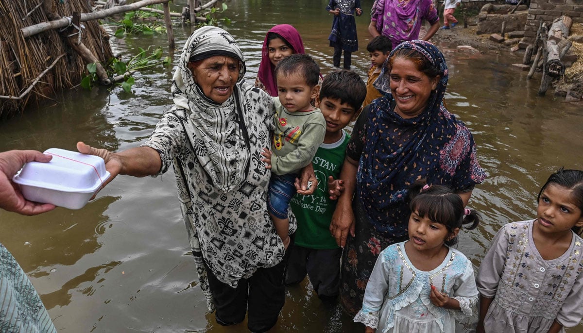 Villages submerged, rescue underway as Punjab reels under deluge 26 Villagers receive food aid in the flood-affected area of Bheki Wala village in Kasur district in this image released on August 27, 2025. — AFP