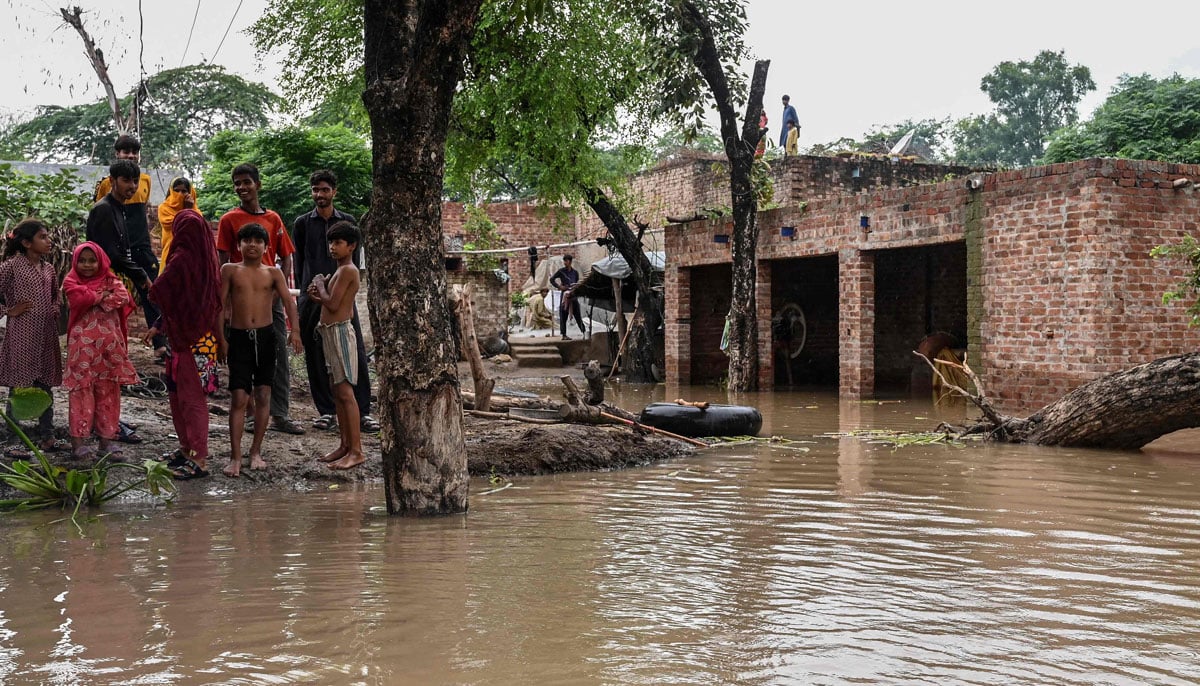 Villages submerged, rescue underway as Punjab reels under deluge 24 Villagers stand outside their houses, partially submerged in floodwaters, after heavy rainfall in the Haqu Wala village at Kasur district in this image released on August 27, 2025. — AFP