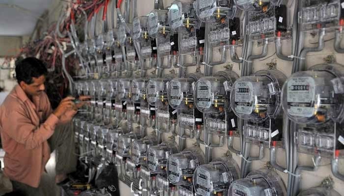 A technician fixes new electricity meters at a residential building in Karachi in this undated photo. — AFP/File