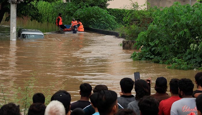 Volunteers from Rescue 1122 search for residents in a flooded area, following monsoon rains and rising water levels in Sialkot, August 27, 2025. — Reuters