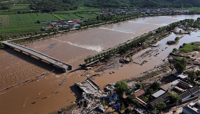 A drone view shows damaged roads and fallen trees next to the overflowing Qingshui river after heavy rainfall flooded the area, in Miyun district of Beijing, China July 29, 2025. — Reuters