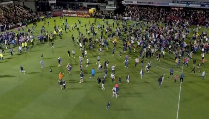 The Grimsby fans are seen celebrating on the ground after their team knocked out Manchester United out of the English League Cup on August 28, 2025. — X@PolymarketFC